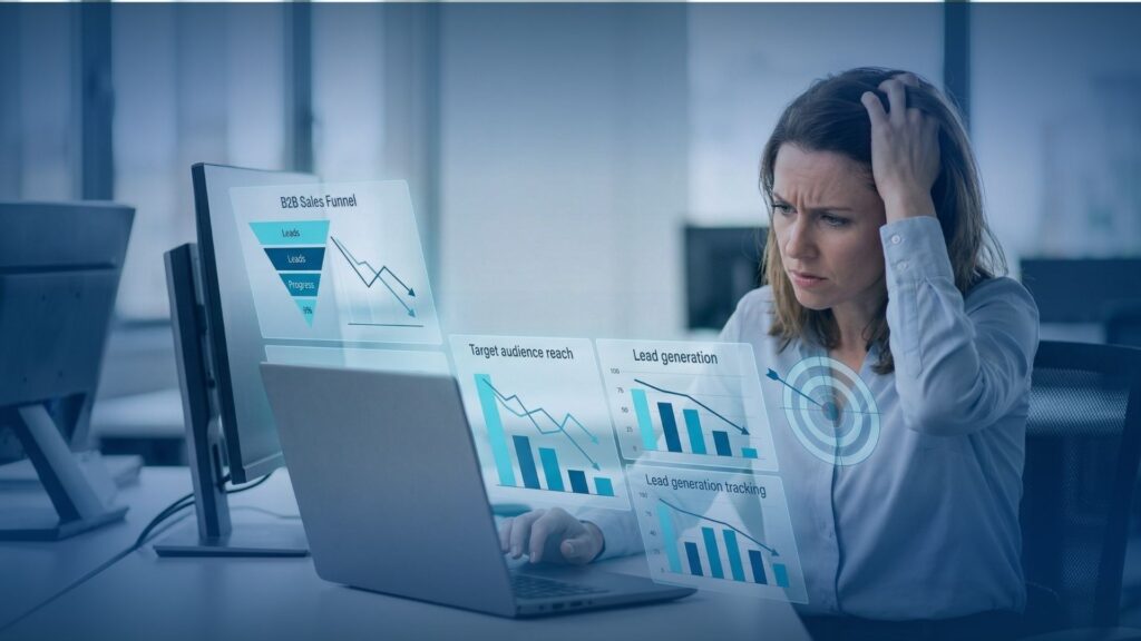 B2B Appointment Setting for MSPs: 10 Tips to Book Sales Meetings 2 A frustrated professional working on a laptop displaying declining sales performance and lead generation charts, highlighting challenges in appointment setting and pipeline growth.