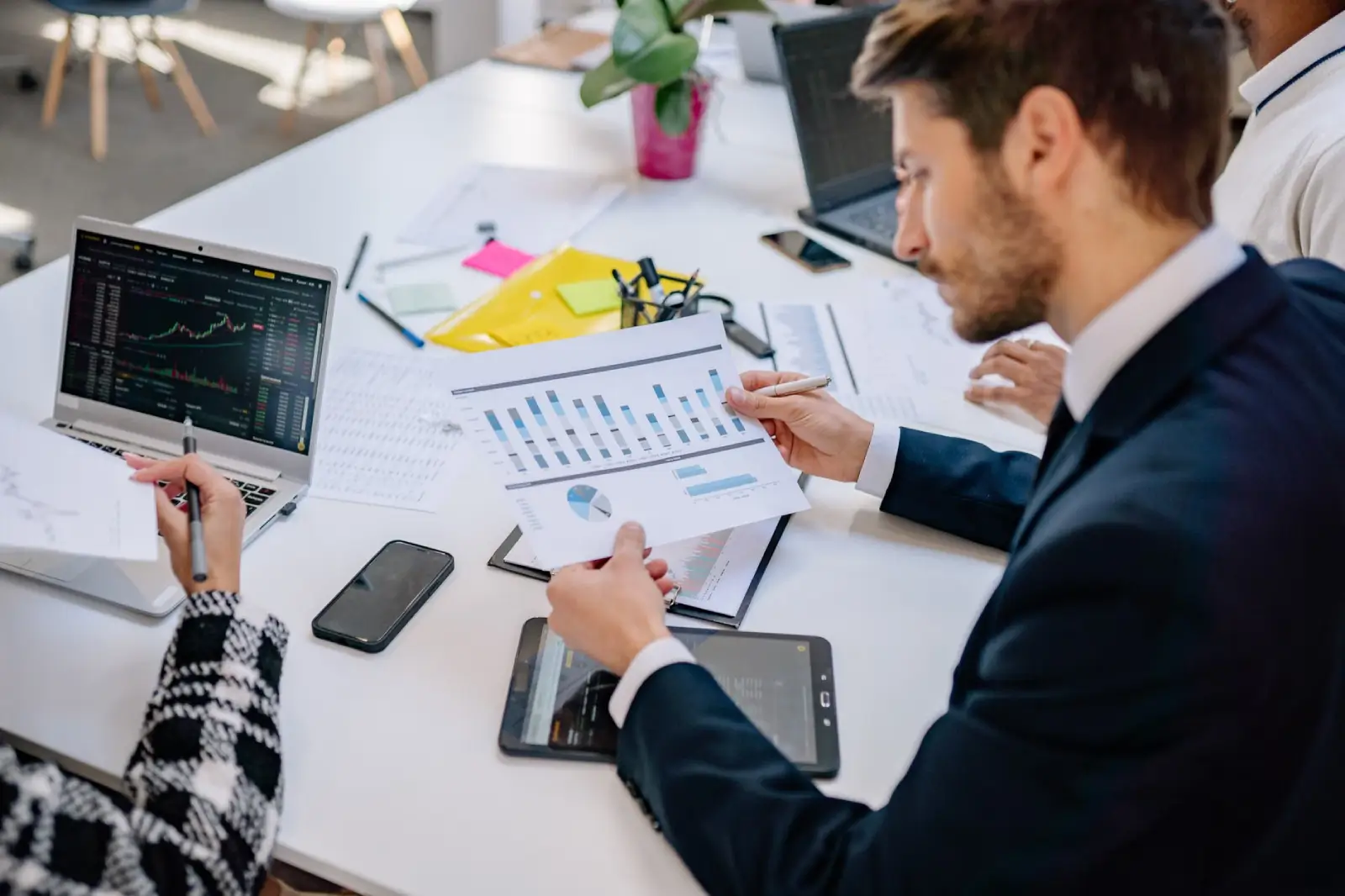 Business team reviewing financial performance and savings data in a modern office